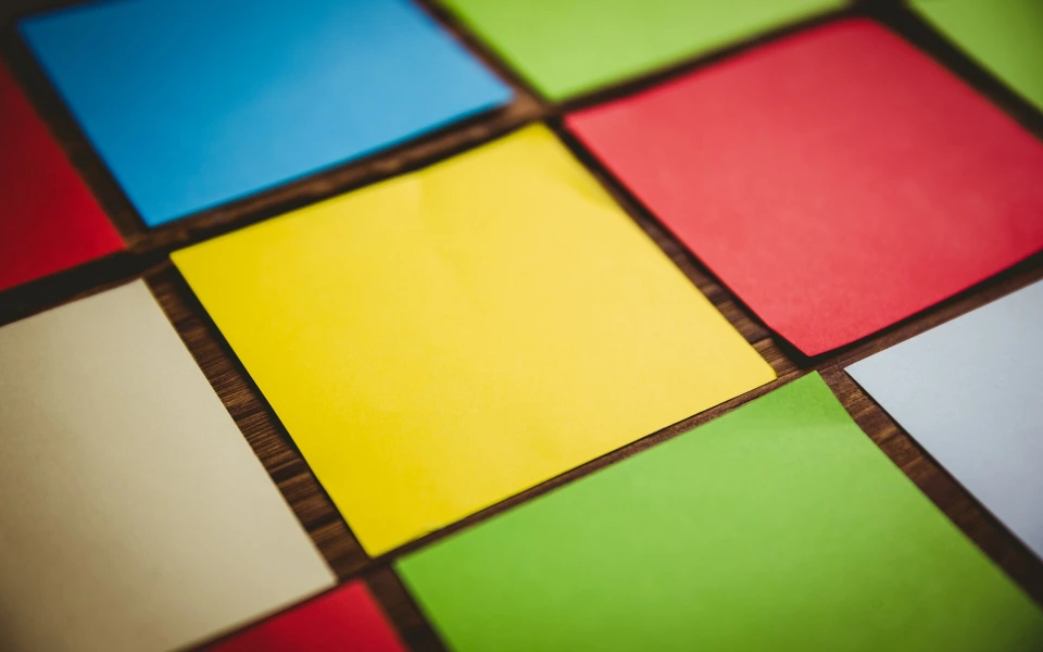 Bunte Papierquadrate in Rot, Gelb, Grün und Blau