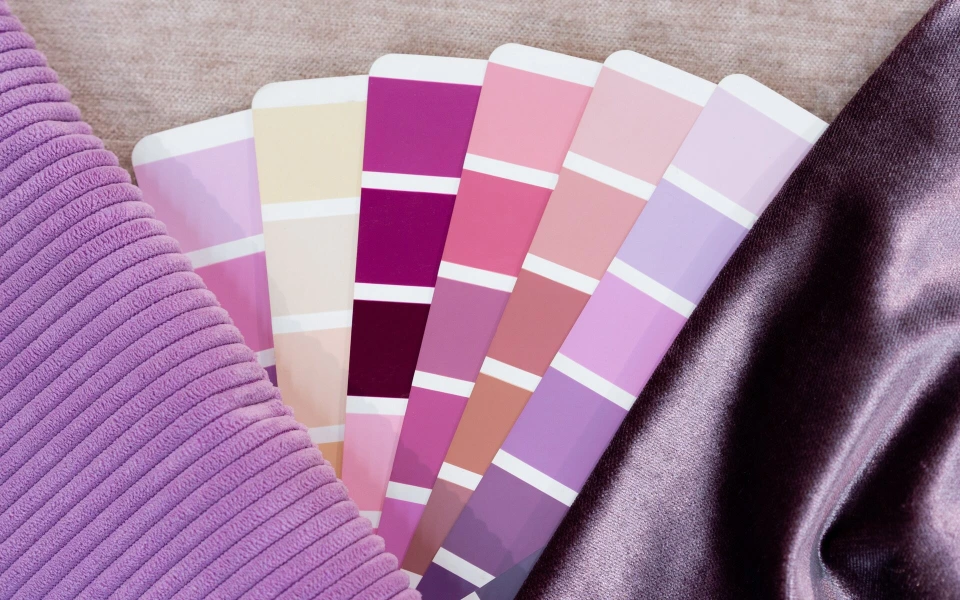 Farbfächer und Stoffmuster in Violett- und Rosatönen