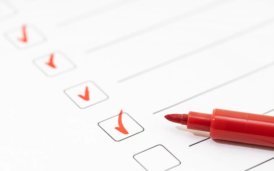 Checkliste mit roten Häkchen und rotem Marker